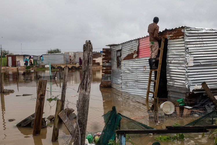 Residents moving through a flooded residential area